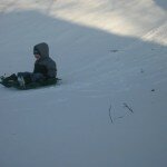 boy-sledding-snow