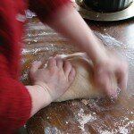 Hands kneading bread dough.