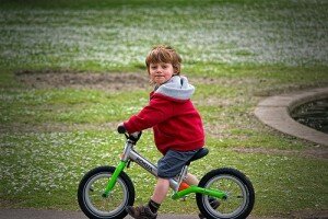 Boy on a bike with no pedals.
