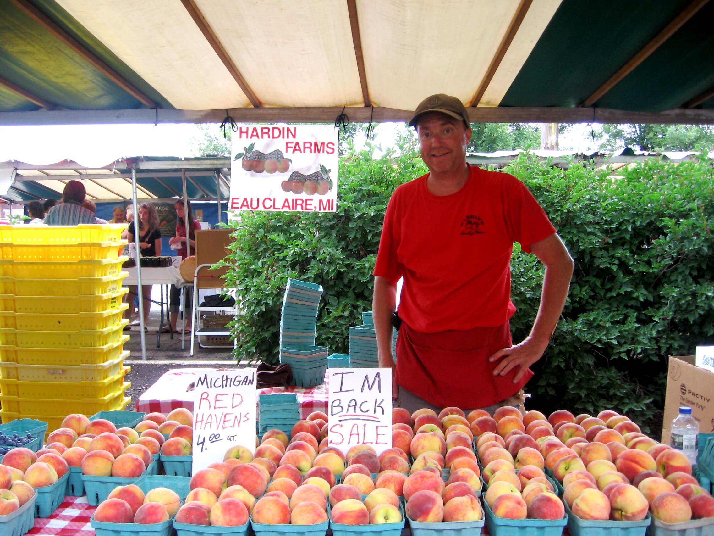 A farmer selling peaches at a local farmers market.
